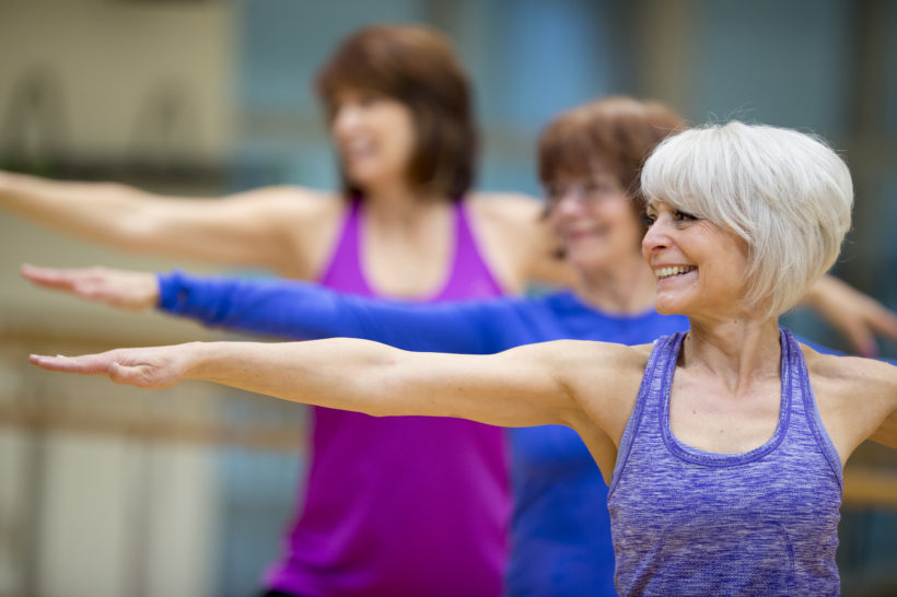 group of senior adult women are taking a yoga class