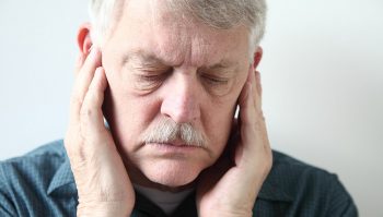 senior man with pain in front of ears