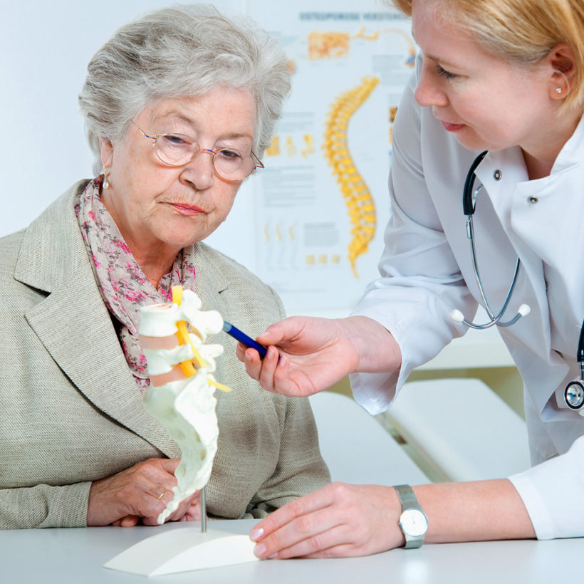 woman doctor examining older woman patient